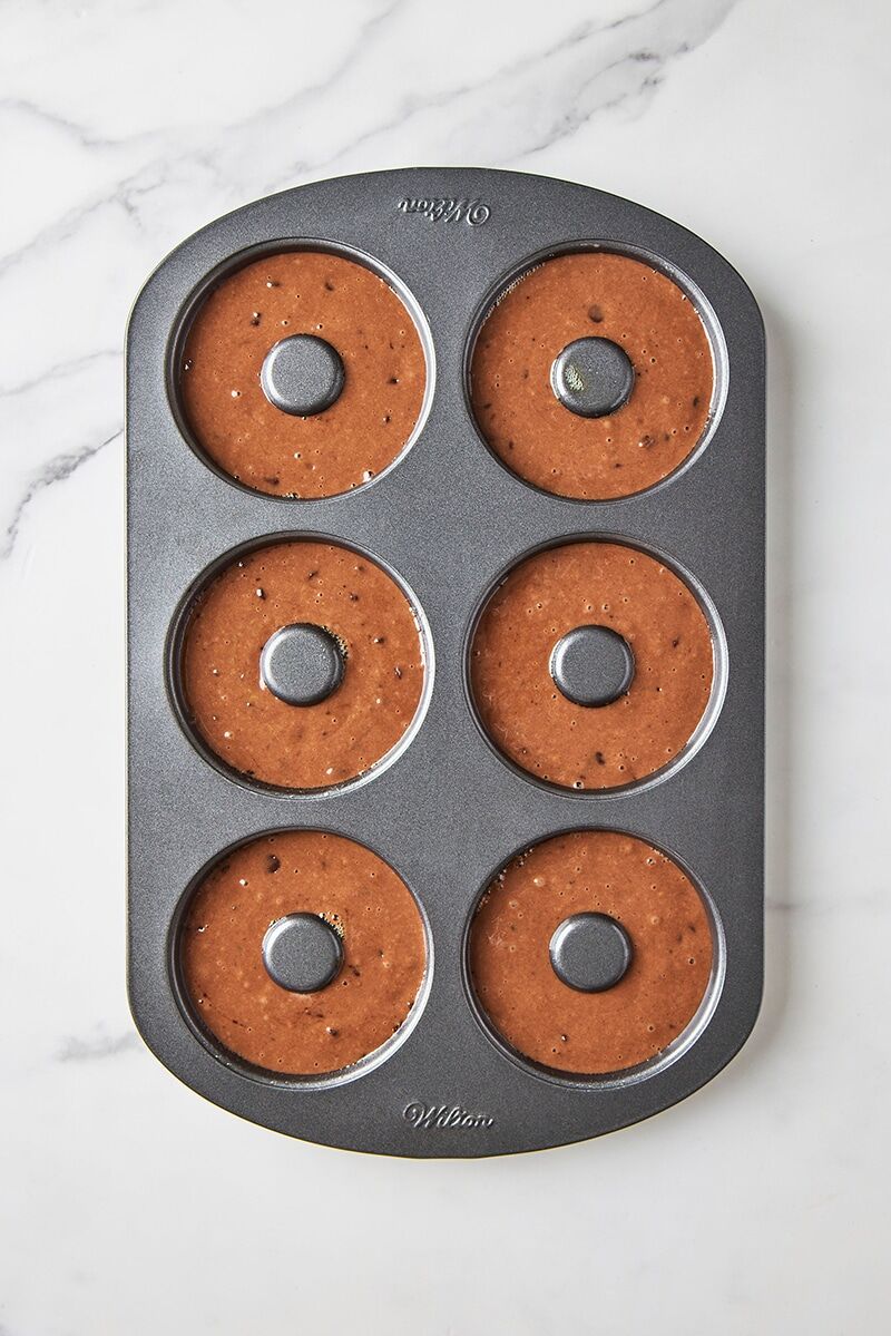Donut batter piped into bake pan