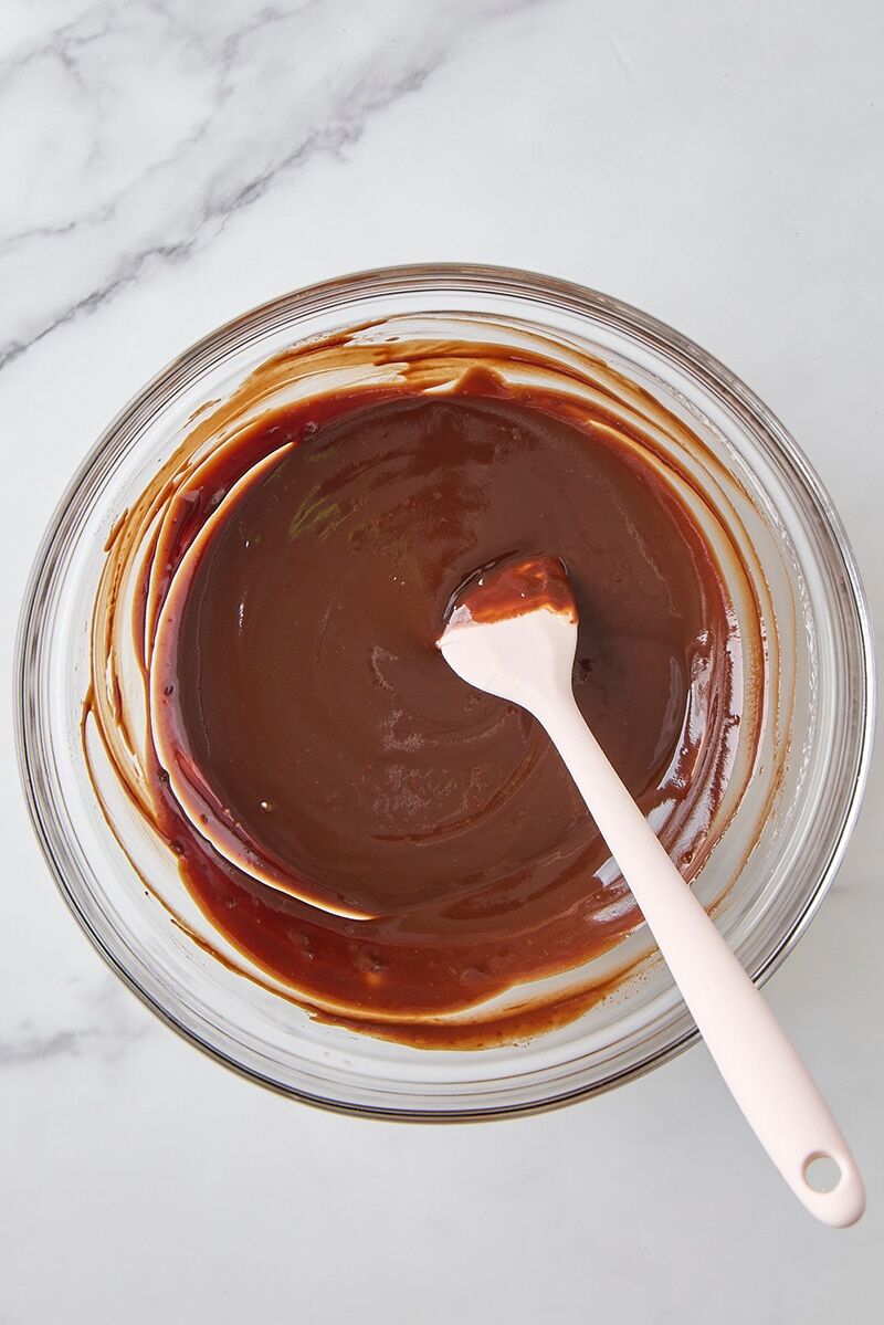 Smooth chocolate glaze in glass bowl with spatula