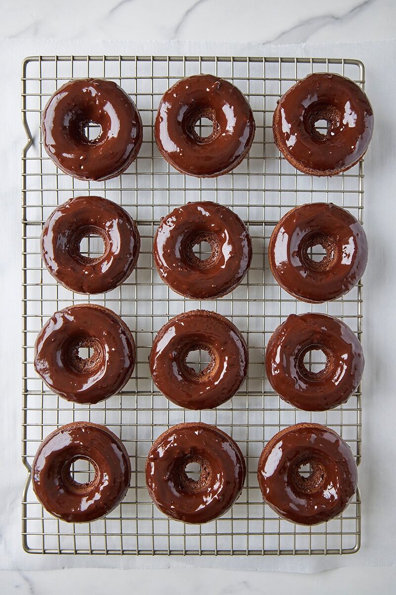 Glazed chocolate donuts on cooling rack
