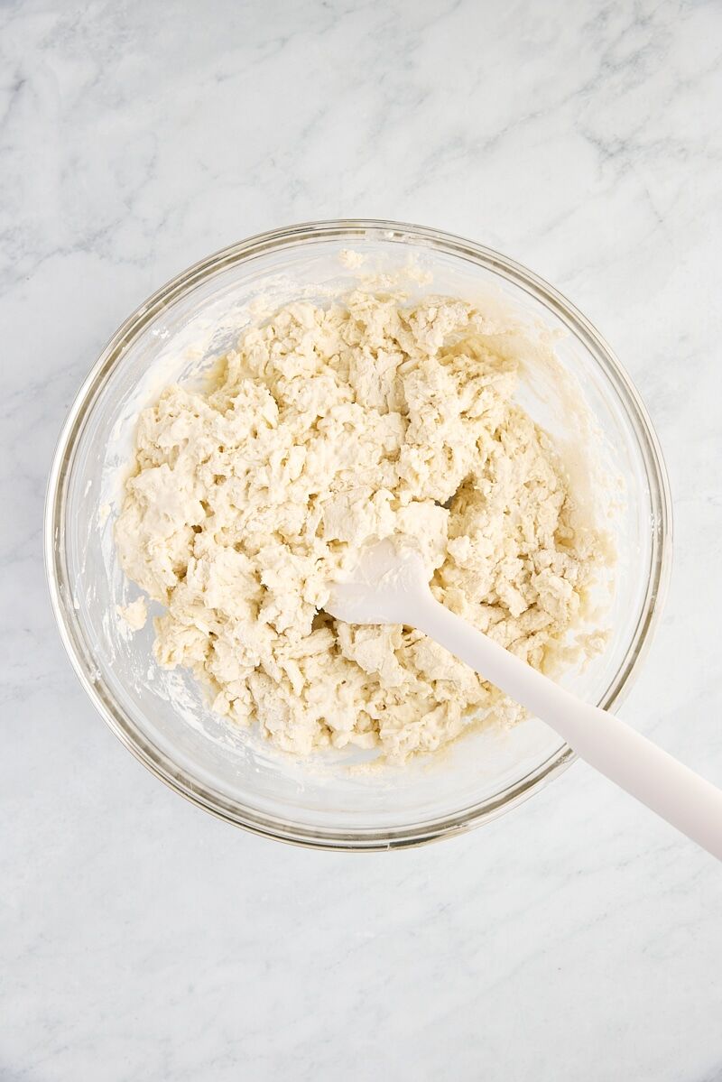 Buttermilk drop biscuit dough in glass bowl with spatula