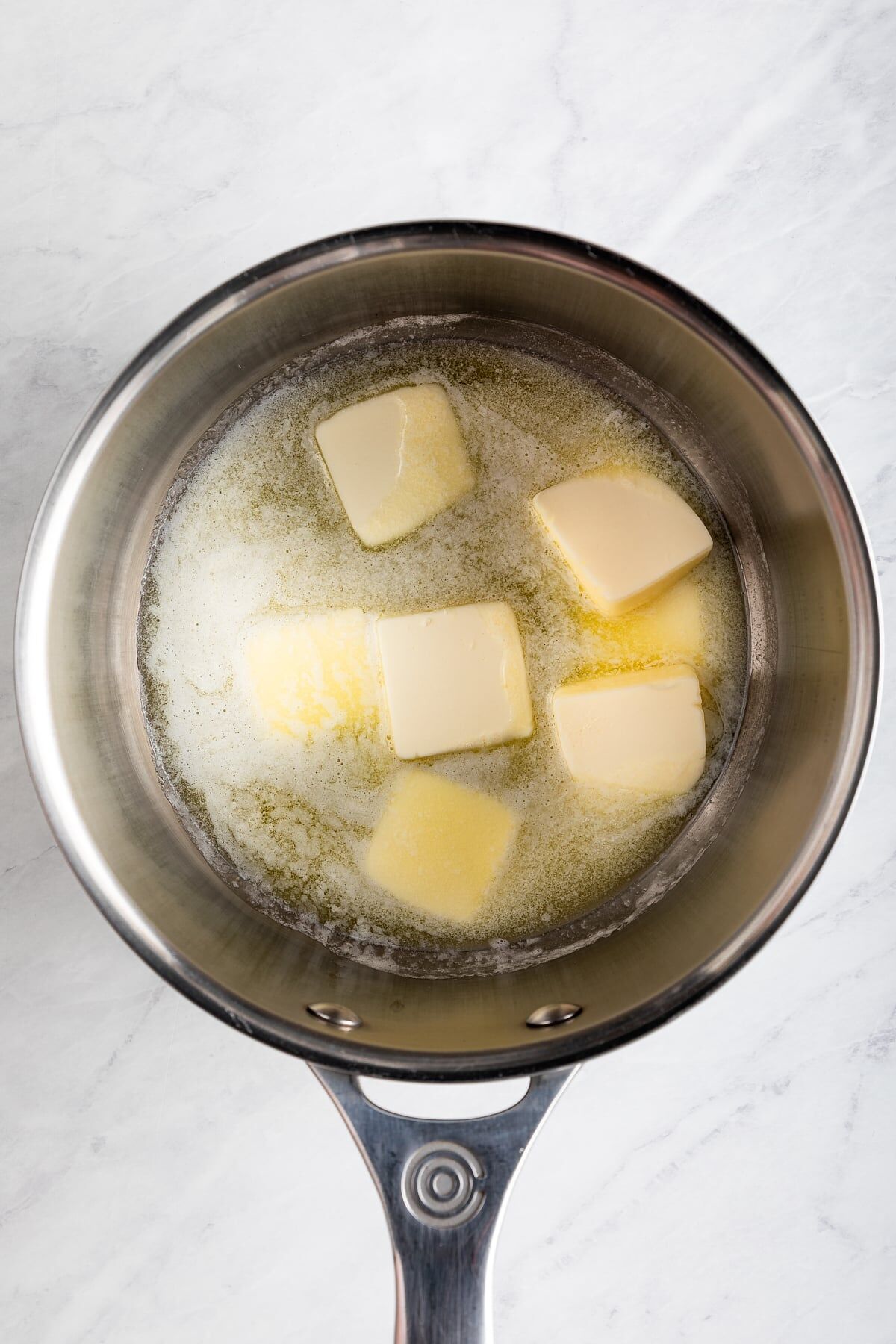 Cubed butter melting in saucepan