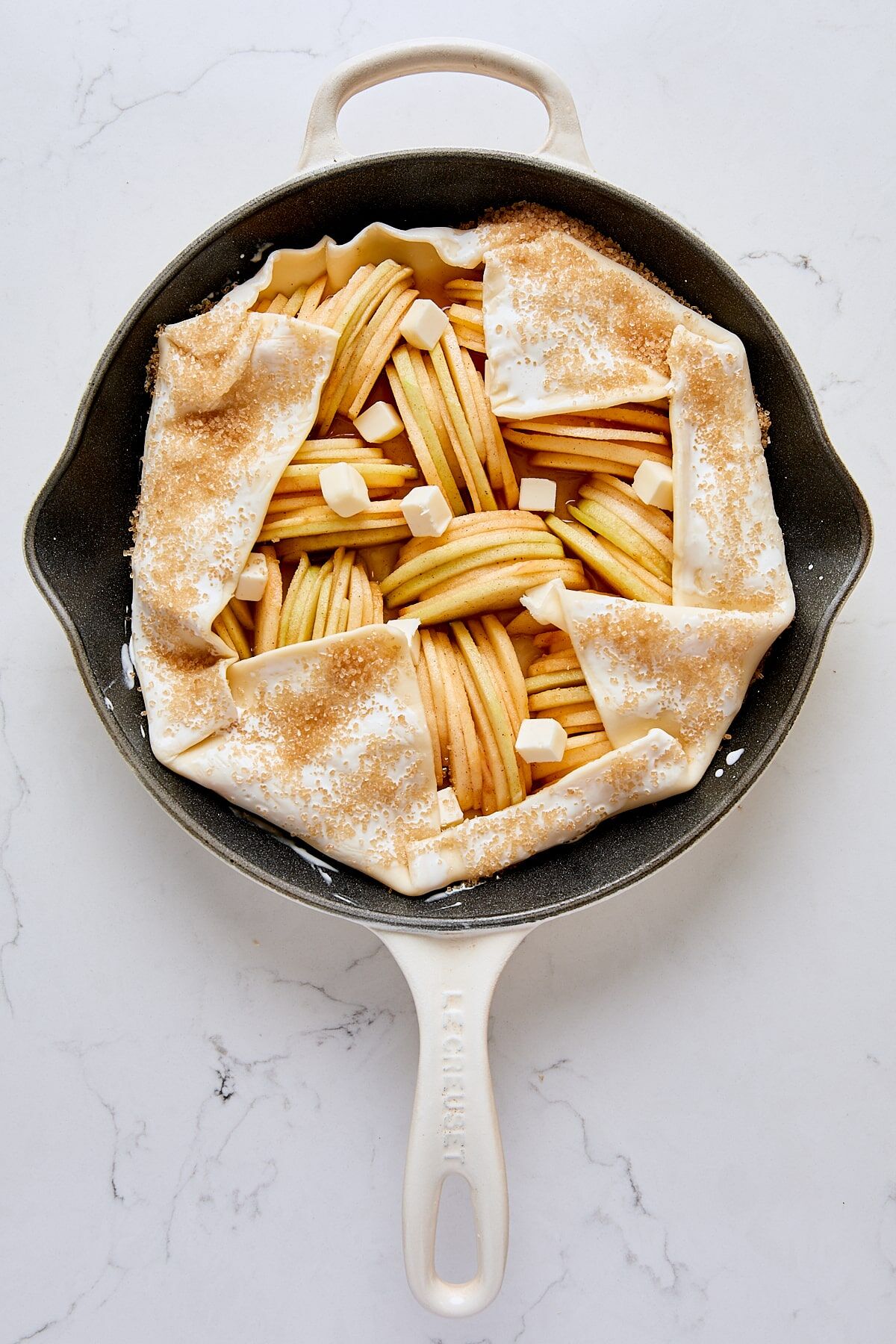 Assembled apple galette in cast iron skillet