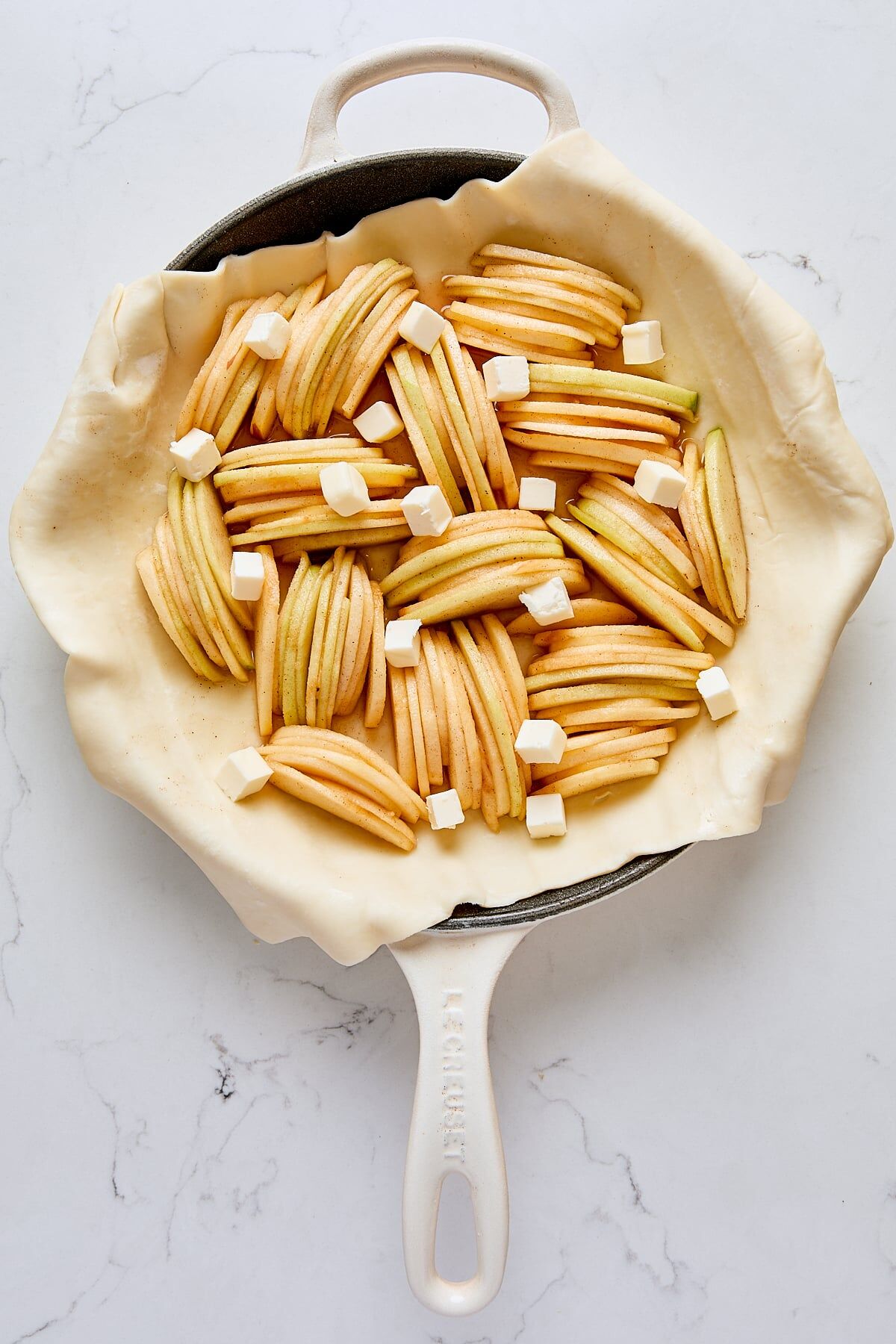 Puff pastry topped with sliced apples and dotted with butter
